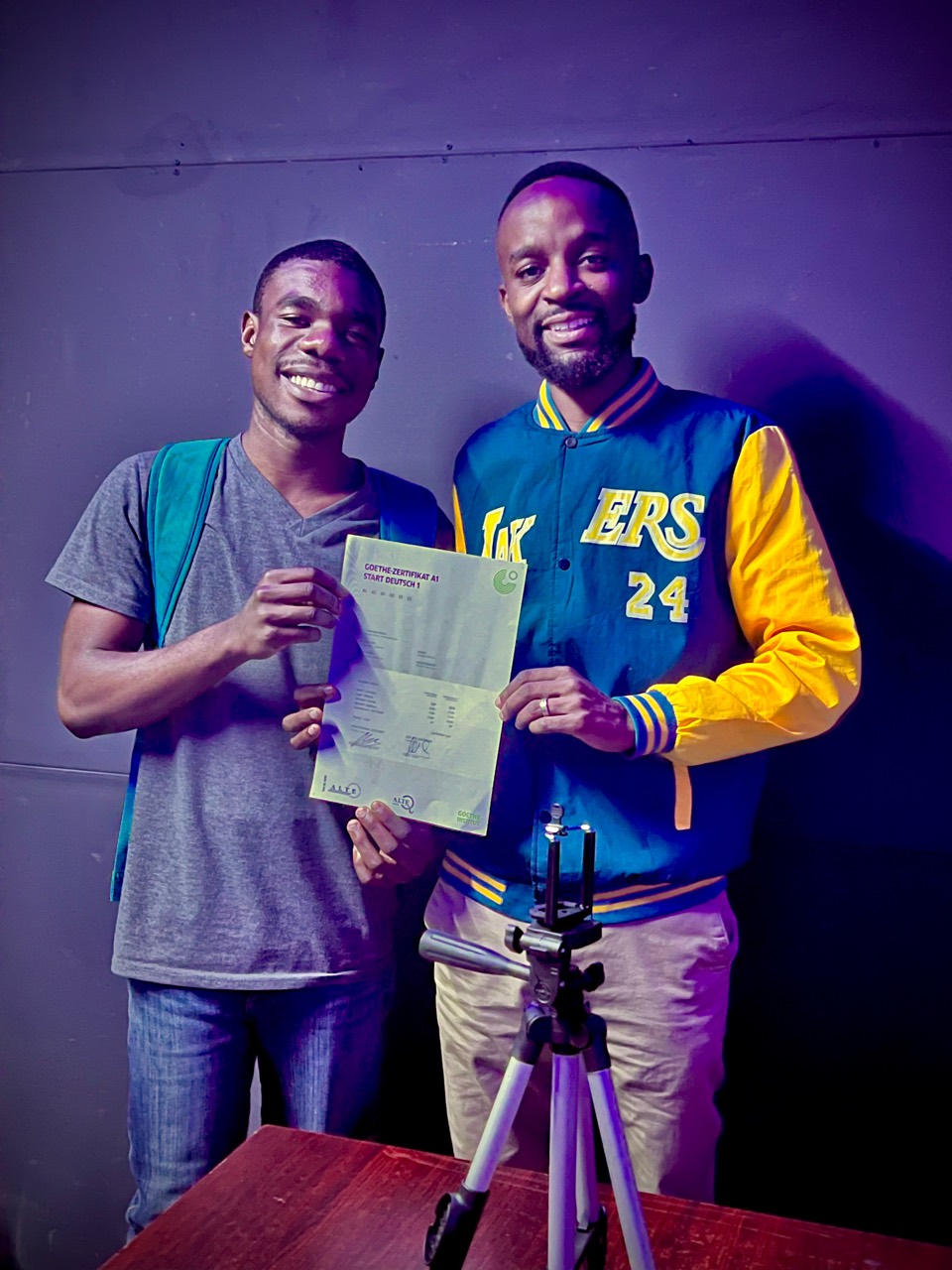 Student holding a Goethe certificate with Isaac Chiwanga